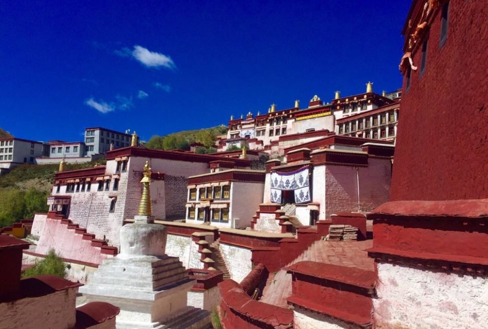 Rooftop view of Ganden Monastery under blue sky