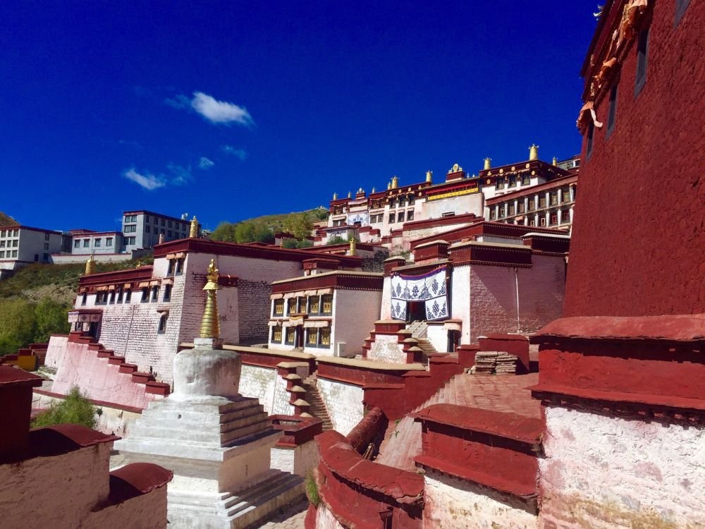 Rooftop view of Ganden Monastery under blue sky