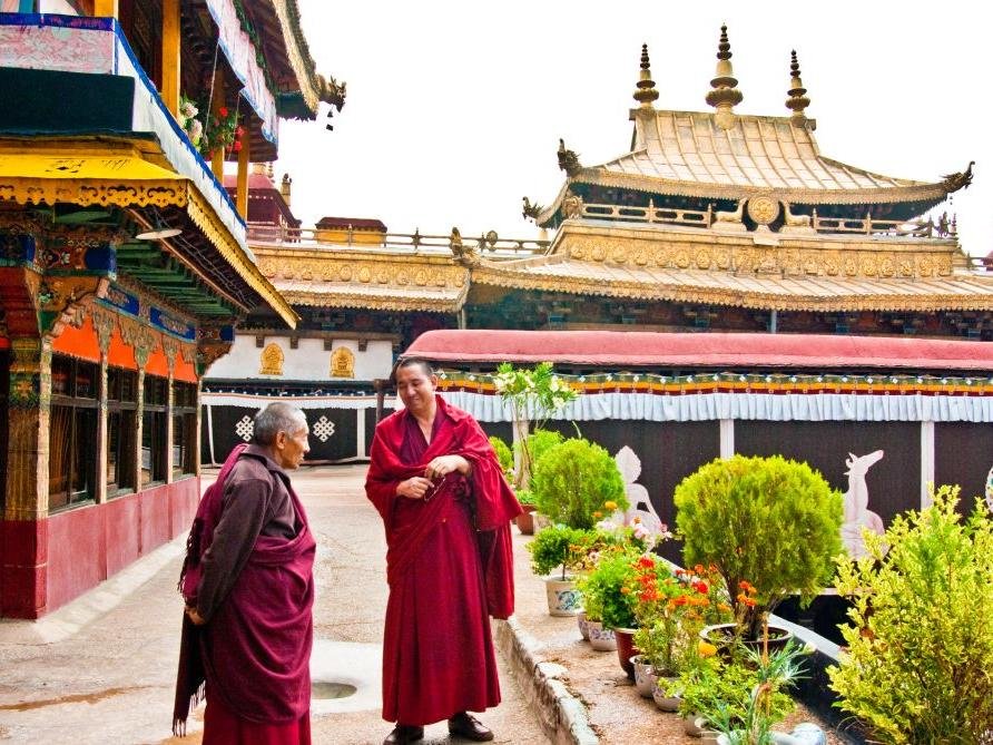 Monks walking in the courtyard of Jokhang Temple, Lhasa